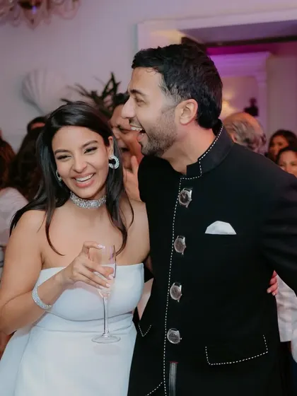 A fun, candid moment from the welcome dinner. The bride is glowing in her modern white dress, with a chic makeup look to match.