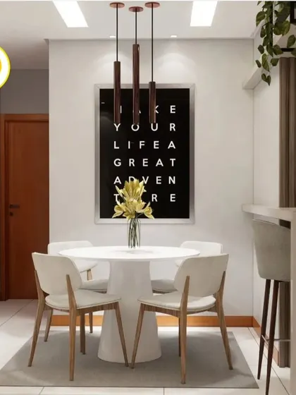 A close-up of the dining area, featuring a white round table and a bold typographic artwork. The design is simple, modern, and perfect for a compact apartment.
