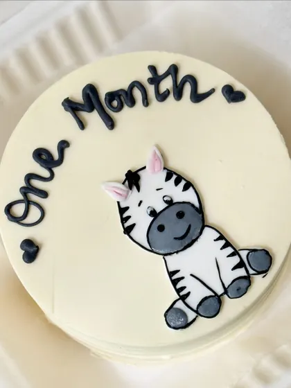 A simple and cute bento cake for a one-month celebration, featuring a hand-drawn zebra.