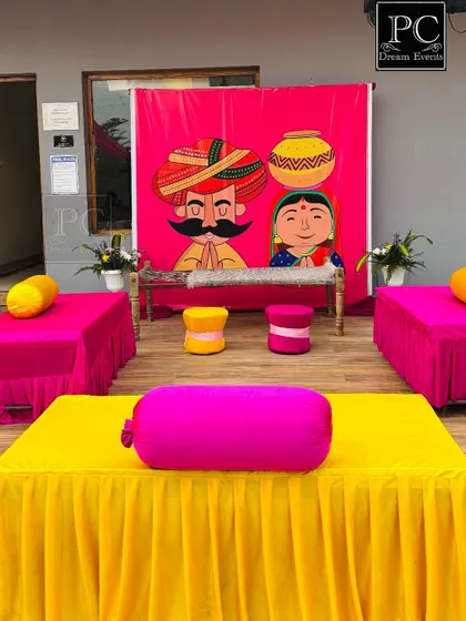 A wider view of the folk-art inspired Haldi decor, showing the low seating arrangement perfect for applying haldi and for guests to sit comfortably.