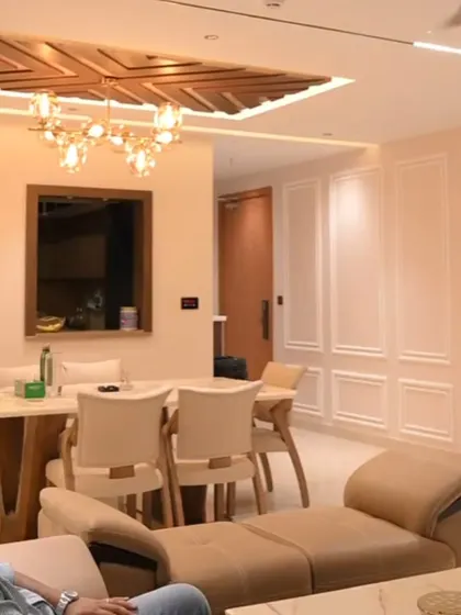 This living room showcases multiple layers of smart lighting, including a modern chandelier and track lights, all integrated into one seamless control system.