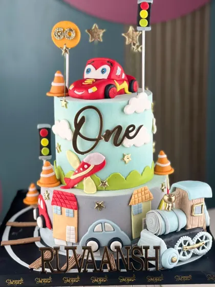 Every kid's dream starts with a cake. This transportation-themed cake for a first birthday is loaded with cars, trains, and planes, turning dreams into a delicious masterpiece.