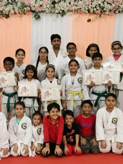 The entire group of karateka at Rejoice International School, showcasing a wide spectrum of belts from orange to purple. This image captures the growth and spirit of our community.