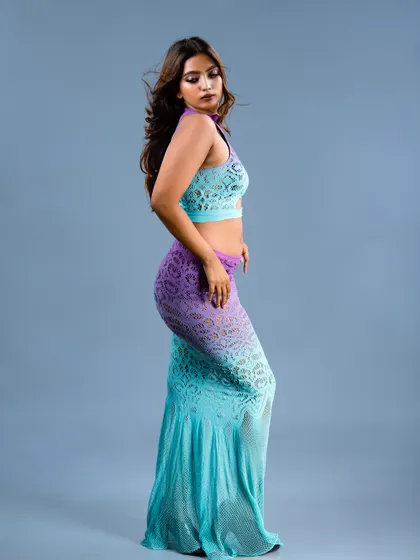 A side profile of a model in a unique ombre lace outfit, showing the flow of the fabric.