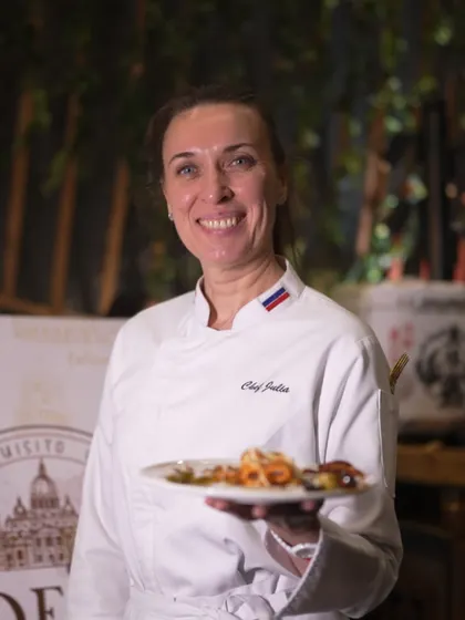 Chef Julia, one of our international culinary experts, smiles as she presents a freshly prepared dish. Our team's friendly and professional demeanor is a key part of the luxury hospitality experience we provide.