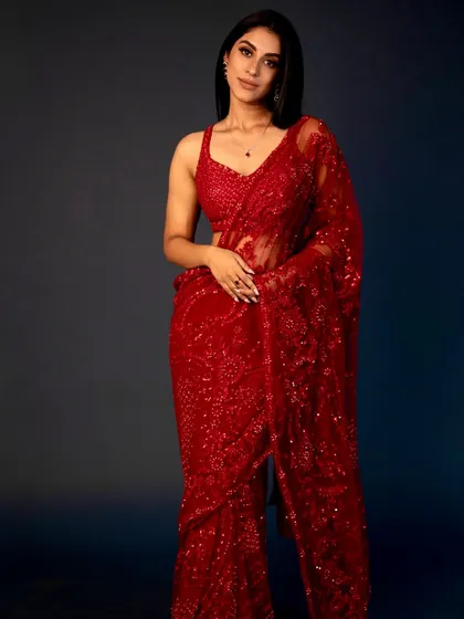 A full-length shot of the red sequin saree look. The makeup is glamorous yet elegant, perfect for a festive occasion or a cocktail party.