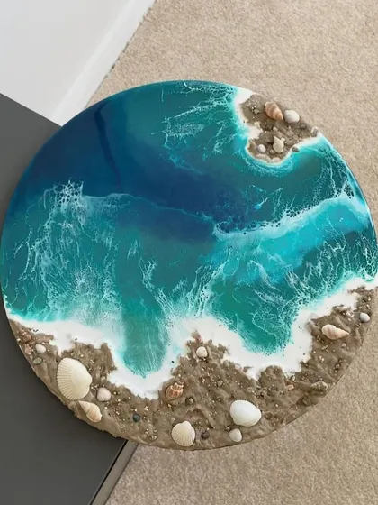 A beautiful example of a finished beach resin art piece, with realistic waves, sand, and shells. This can be made as a wall hanging or a clock.