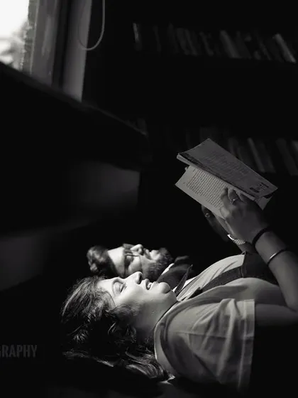 A quiet, intimate moment of a couple reading together, captured in a beautiful black and white composition that focuses on emotion and light.