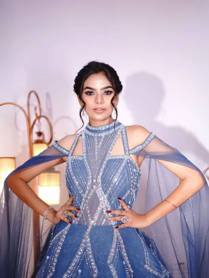 A close-up of our "Frozen" inspired blue gown with cape sleeves and intricate silver beadwork.