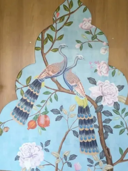 A custom-framed mural of peacocks on a flowering branch, designed to fit a uniquely shaped wall space, adding an element of bespoke artistry.