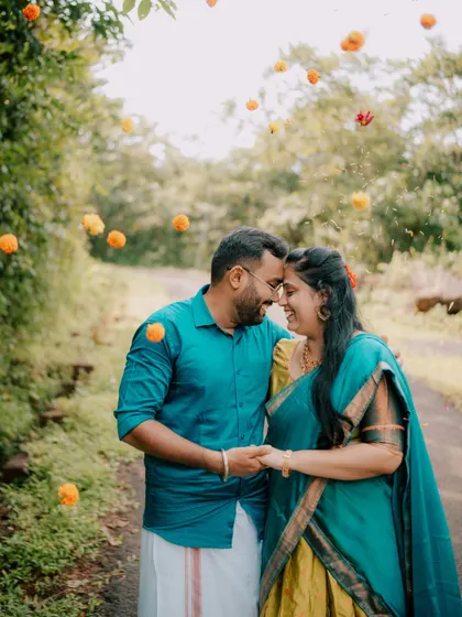 A romantic close-up of a couple with flowers showering down, adding a touch of magic to their pre-wedding photo.