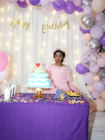 Seeing the birthday girl enjoy her special setup is the best part. This simple backdrop with fairy lights and a pastel balloon arch created the perfect spot for her to pose with her cake.