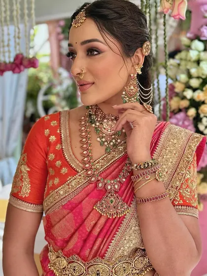 A side profile of Malavika, highlighting her intricate ear chains and the flawless blend of her makeup.