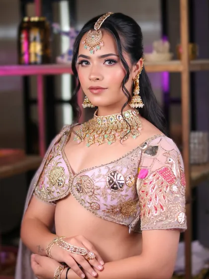 A vision in pastel pink. This engagement or sagan look features soft pink eyeshadow and a dewy finish, paired with a beautifully embroidered lehenga.