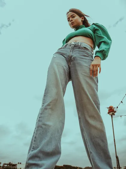 The low angle creates a powerful, heroic silhouette. This technique is great for making a strong fashion statement in an ad campaign or editorial.