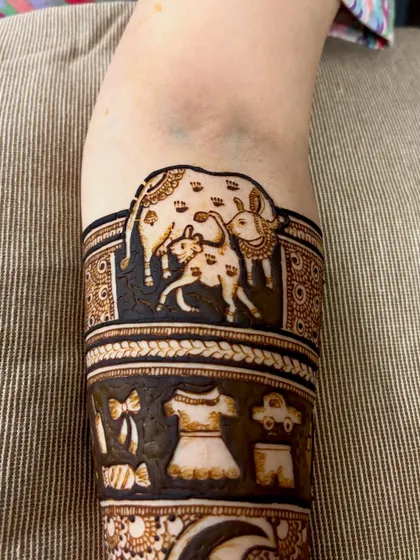 Detail of the mother cow and calf illustration, a touching symbol of motherhood included in a baby shower mehendi.