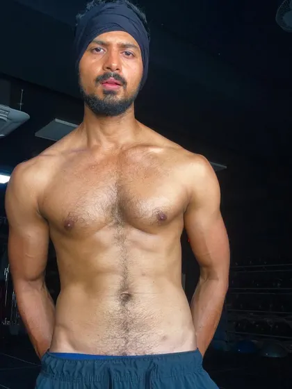 A raw, intense look in the gym. The turban adds a unique element to this physique shot.