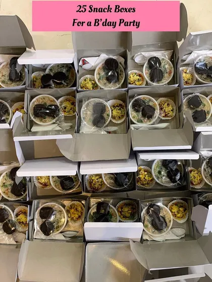 25 snack boxes filled with chocolate cookies, veg fried rice, and mini pizza for a birthday party.