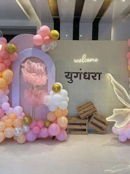 A closer view of the pastel-colored butterfly theme setup, highlighting the organic balloon garlands and wooden crate props.