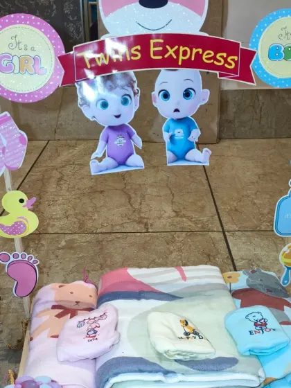 This section of the hamper is for shared items like blankets and towels, decorated with 'It's a Girl' and 'It's a Boy' signs.