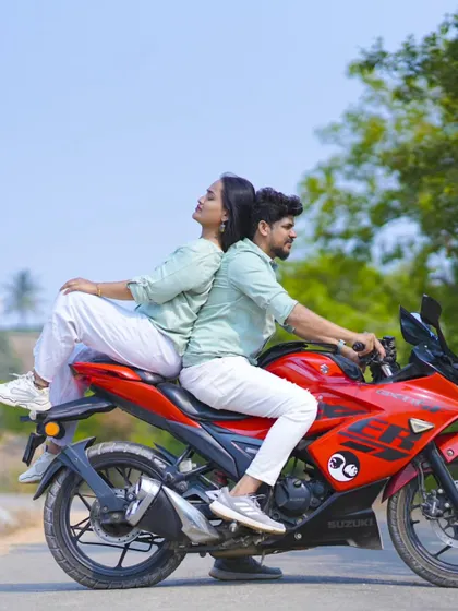 A cool and stylish pre-wedding shot with the couple posing on a red sports motorcycle.