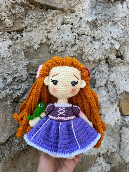 I enjoy bringing beloved characters to life, like this Rapunzel doll. I focused on getting the details right, from her long, braided orange hair to the little Pascal on her arm.