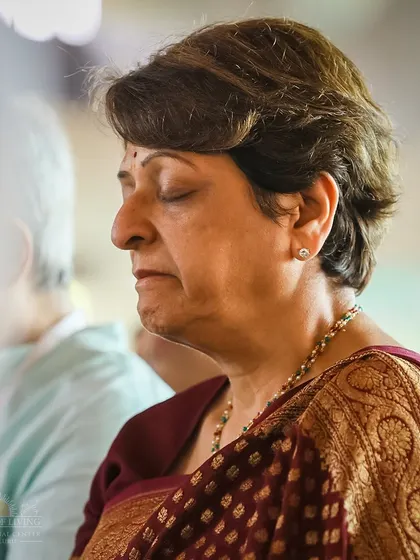 A participant in a state of serene meditation during a Homa ceremony. Our programs create an environment where you can easily let go of thoughts and experience deep inner peace.