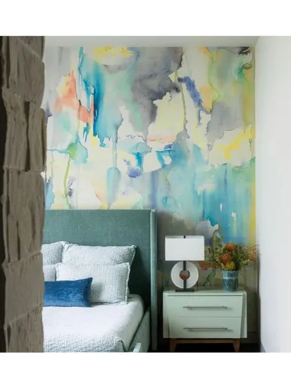 This abstract, watercolour-style wallpaper from the 'Blur' collection acts as a piece of art behind the bed. It's a fantastic way to introduce colour and a modern, painterly feel to a bedroom.