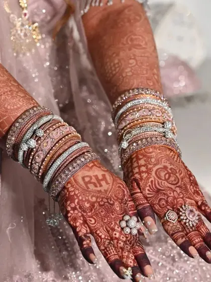 The rich, dark stain of this personalized bridal henna looks stunning with the bride's rings and bangles.