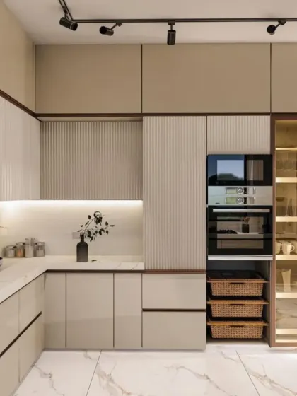 This kitchen design uses a mix of fluted and plain cabinet fronts for textural interest. It includes a tall unit for built-in ovens and a glass-fronted pantry with internal lighting.