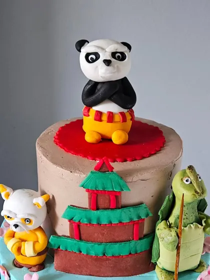 A close-up of the handcrafted toppers from the Kung Fu Panda cake. You can see the expressions on Po, Master Shifu, and Master Oogway, each sculpted with care.