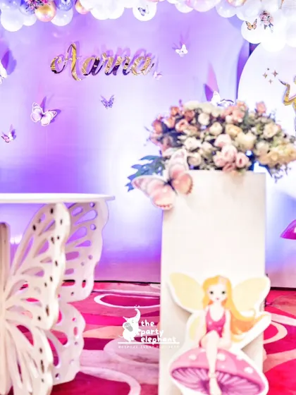 A close-up of the whimsical decor, featuring a butterfly-shaped table, fairy cutouts, and fluttering butterfly accents on the wall.