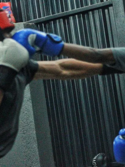A fighter practices his defense, blocking a punch with his headgear and gloves. A tight guard is crucial in boxing.
