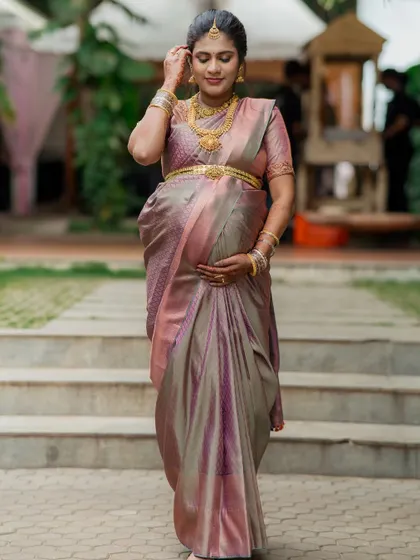 An elegant walking portrait of the expectant mother during her Valaikaapu ceremony. Her grace and joy are beautifully captured as she adjusts her hair, adorned in a stunning saree.