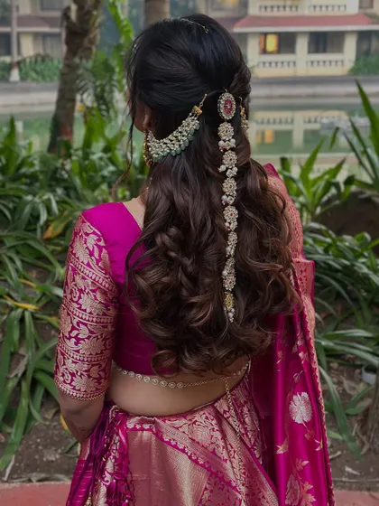 Another angle of the half-up style, showing how the hair jewelry beautifully complements the bride's magenta silk saree.