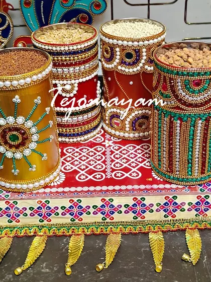 A set of traditional containers, meticulously decorated with beads and jewels, ready to be filled with auspicious items for a housewarming ceremony.