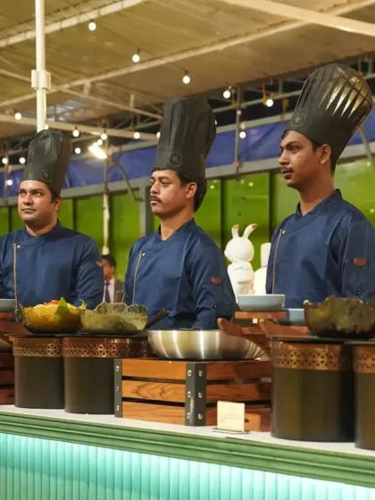 Our chefs stand ready at their station. Their tall hats and professional uniforms are a symbol of their expertise and the high standards of our kitchen.