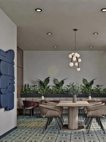 Every corner is a design opportunity. This shot highlights a blue sculptural art piece on the wall, adding a modern, artistic touch to the café. The mix of seating, including banquettes and chairs, offers flexible options for employees.