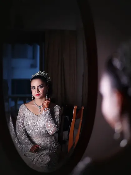 A bride looking at her reflection in the mirror, a moment of contemplation before her engagement ceremony. She looks like a princess with her tiara.