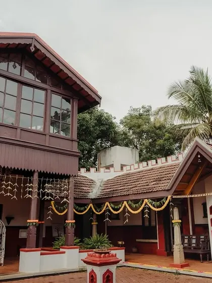 A wide view of the traditional courtyard house, adorned with hanging flower strings for a festive and welcoming wedding atmosphere.