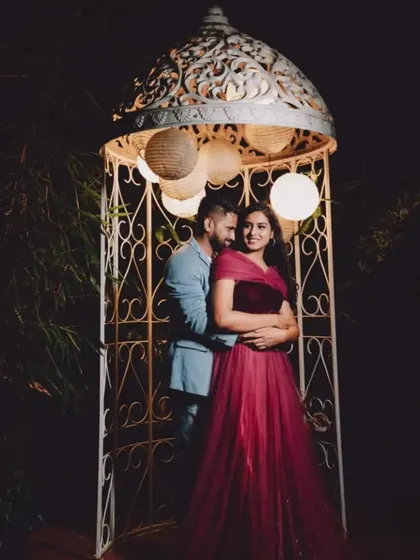 A romantic nighttime shot of a couple in a lighted gazebo. The client's maroon gown adds to the intimate atmosphere.