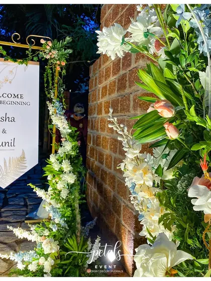 A close-up of the hanging welcome banner for a reception, part of a modern broken arch theme that combines elegance with a touch of rustic charm.