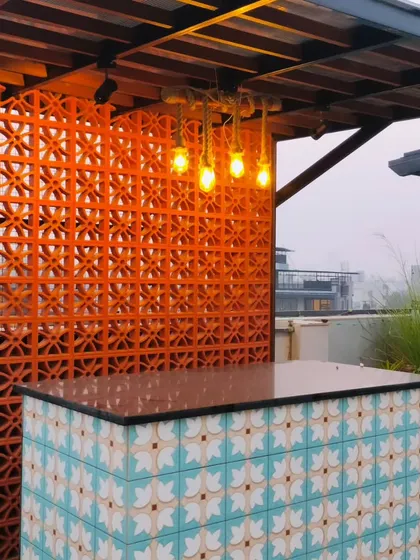 A close-up of the custom bar at the Palam Vihar project, showing the detail of the patterned tiles and the terracotta screen.