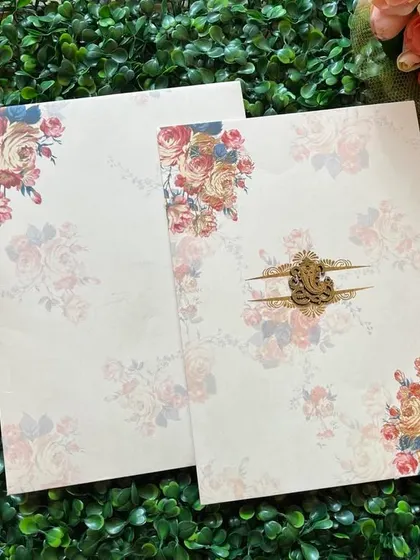 This invitation features a beautiful watercolor floral design with a central Ganesha emblem, blending modern art with traditional blessings.
