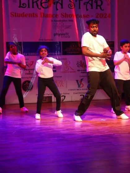 Teaching on stage, an instructor guides students through the choreography.