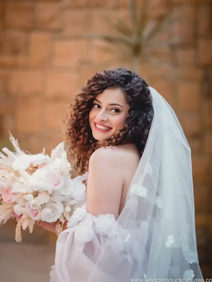 A happy glance over the shoulder. This bride's joy is contagious, and her curly hair looks absolutely stunning.