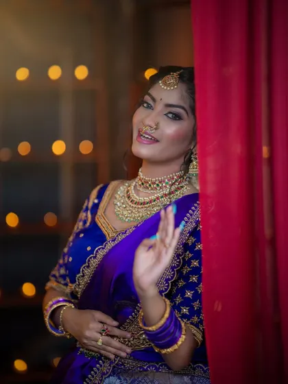 A playful close-up showing the maang tikka, nose ring, and choker from our temple jewellery collection.