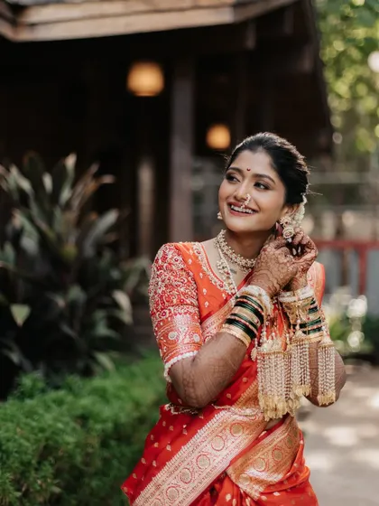 A candid moment of the bride adjusting her earring, a smile playing on her lips.
