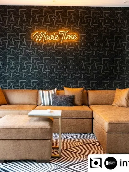 For this home, we designed a dedicated home theatre that’s perfect for movie nights. The space features a comfortable, oversized sectional sofa, a bold geometric wallpaper, and a fun "Movie Time" neon sign to set the mood. It’s a space designed for relaxation and making memories with family.