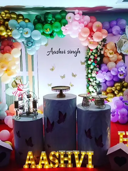A whimsical fairy garden theme for Aashvi's first birthday. We used colourful balloons, large butterfly wing props, and a light-up marquee number "1" to create a vibrant and magical setting.